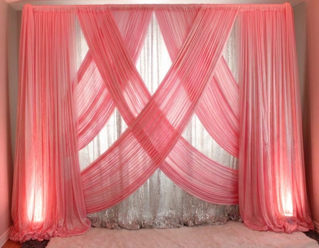 Elegant pink wedding backdrop with draped fabric and white sequin curtain for romantic event decor.